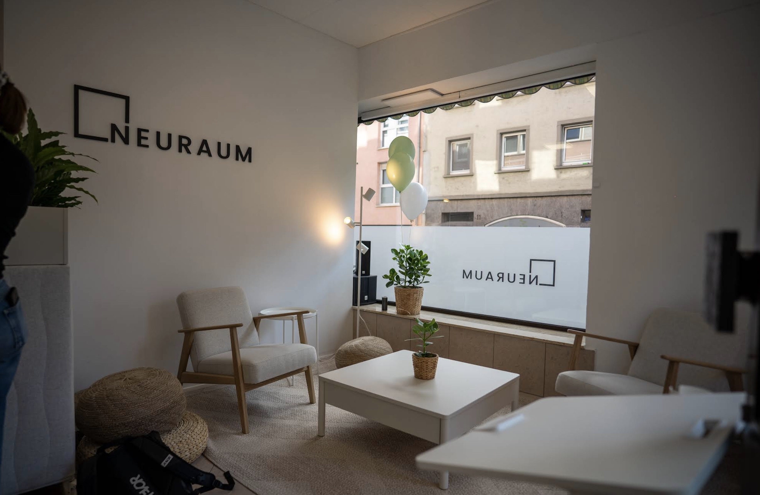 Neuraum Würzburg — heller Loungebereich mit Logo-Wand und Fenster zur Gerberstraße
